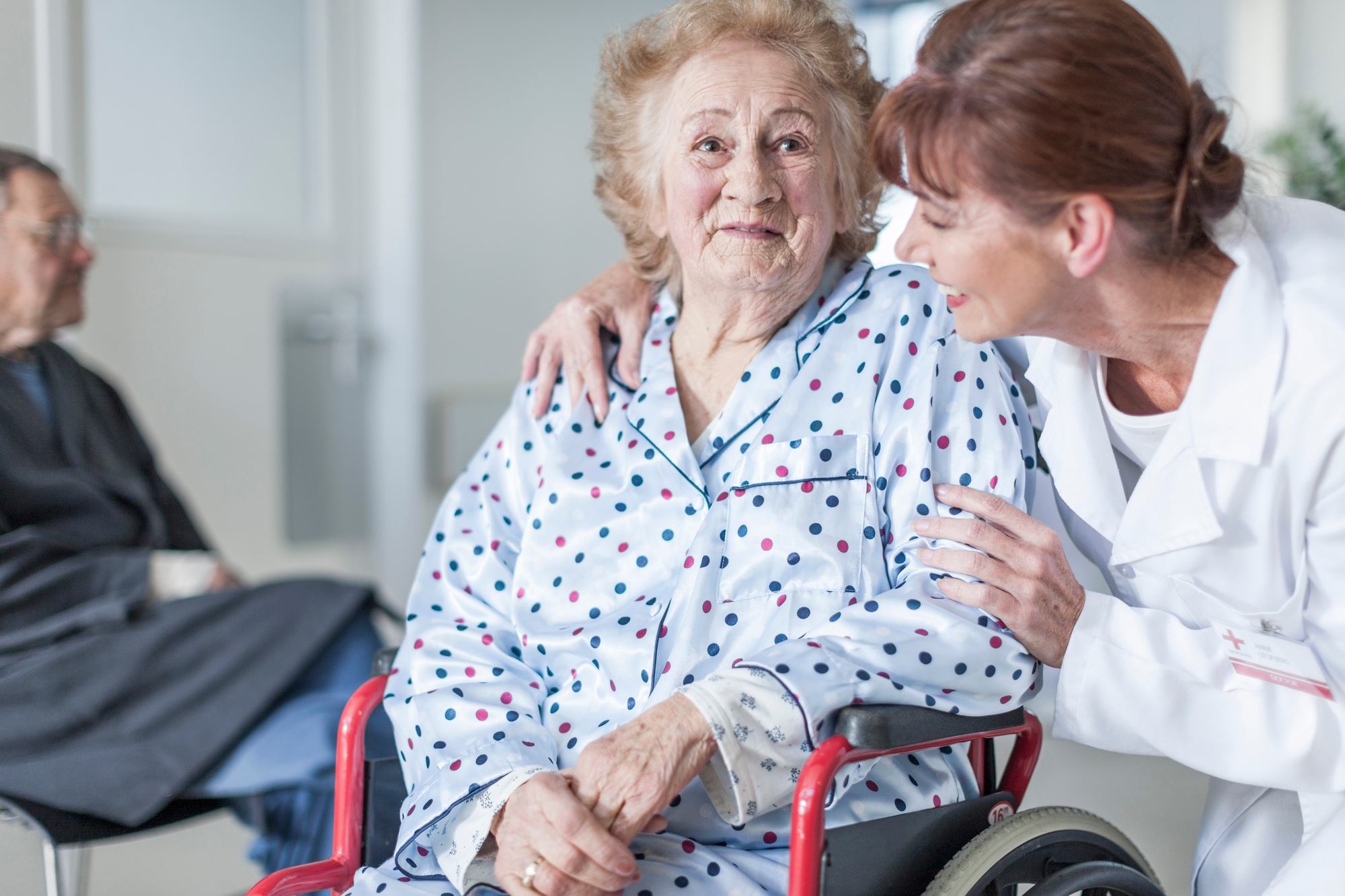 Doctor caring for elderly patient in wheelchair