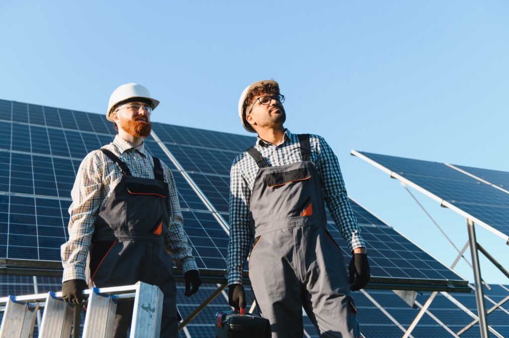 Workers installing solar panels in solar power station